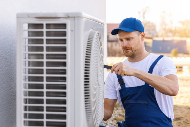 HVAC technician servicing an outdoor air conditioner in Bellflower